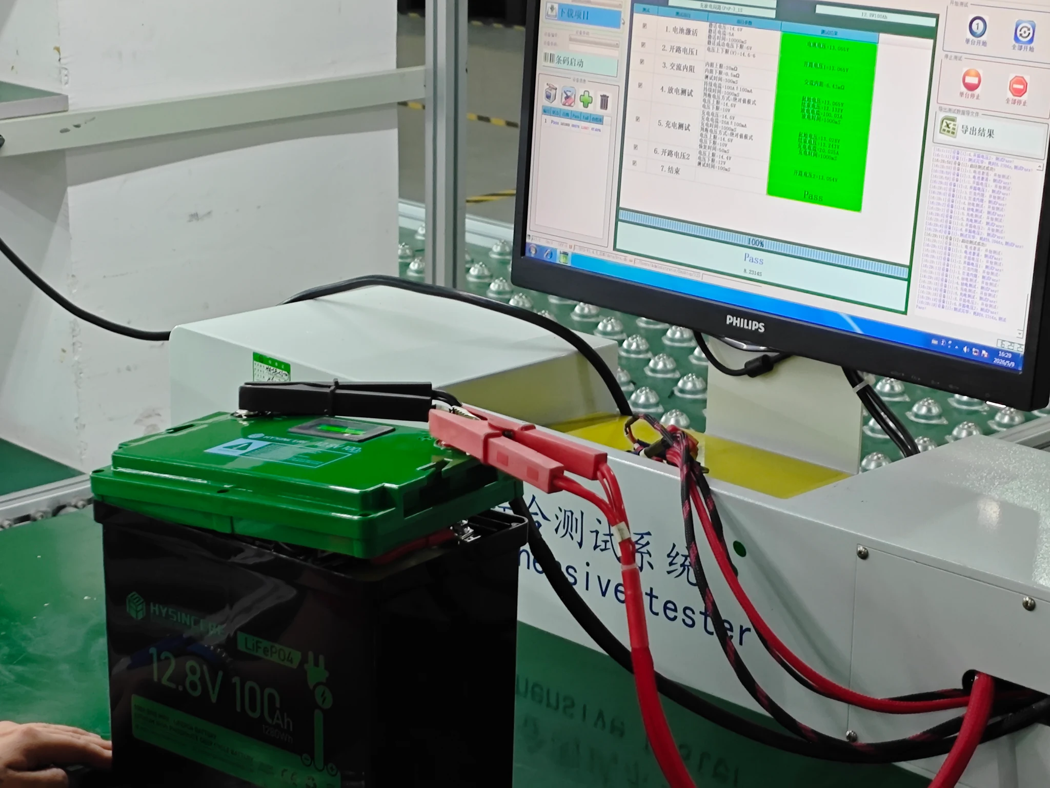 Hysincere Akku mit angeschlossenen Prüfleitungen neben dem Monitor des Prüfsystems im Werk